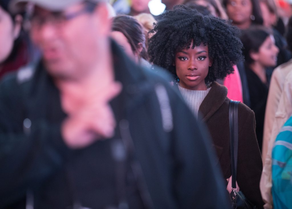 Pretty African American woman on a crowded city sidewalk